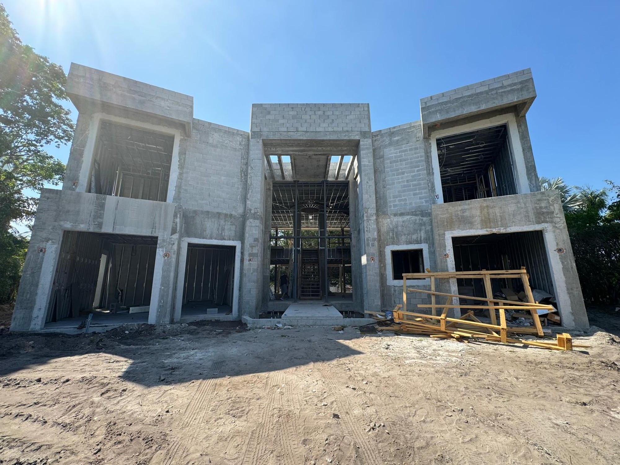 The residence at concrete-shell stage: bare structure with open, unglazed window and door openings